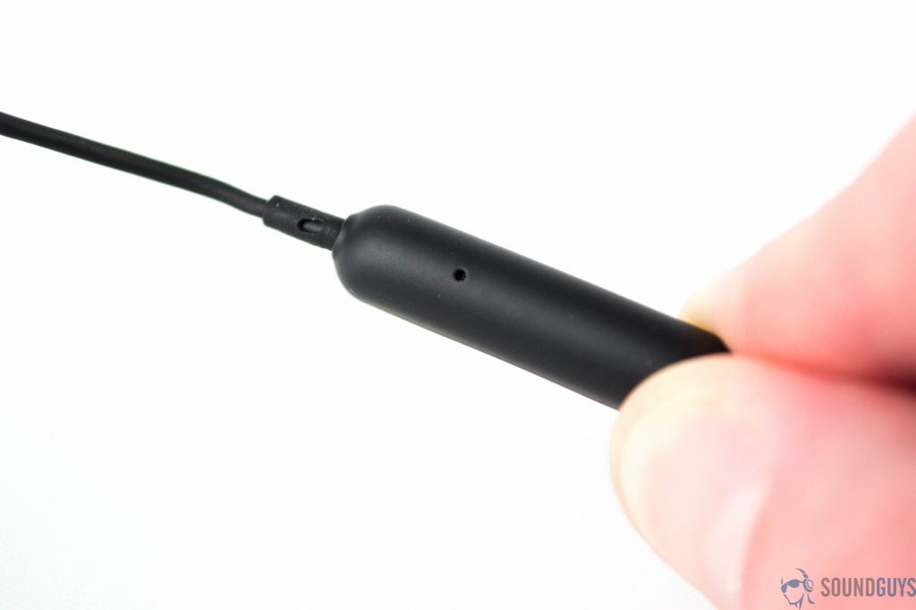 A hand holding the Polk Nue Era microphone against a white background.