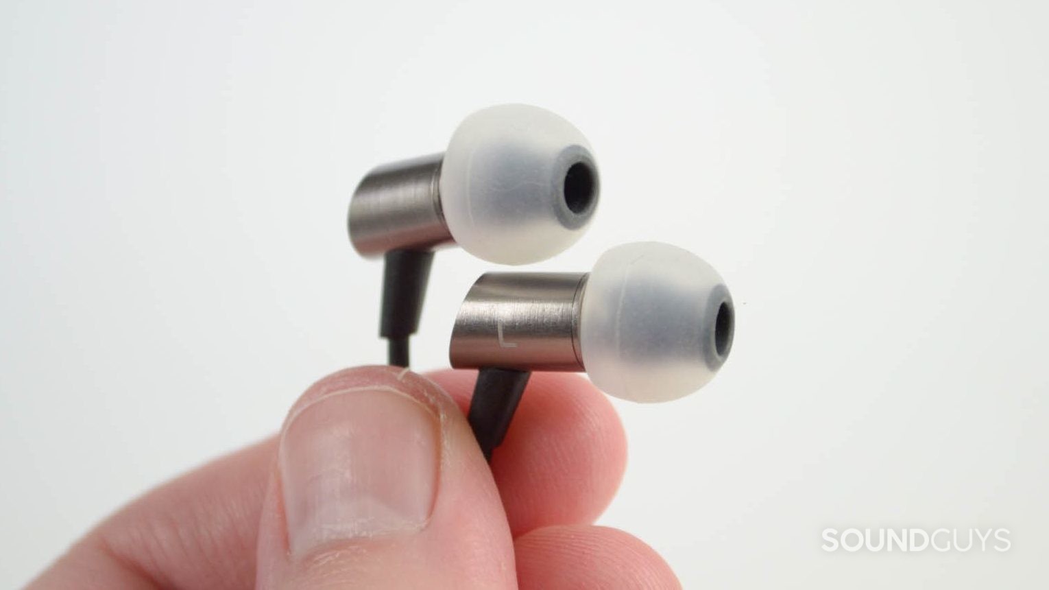 A man holds the RHA S500i earbuds.