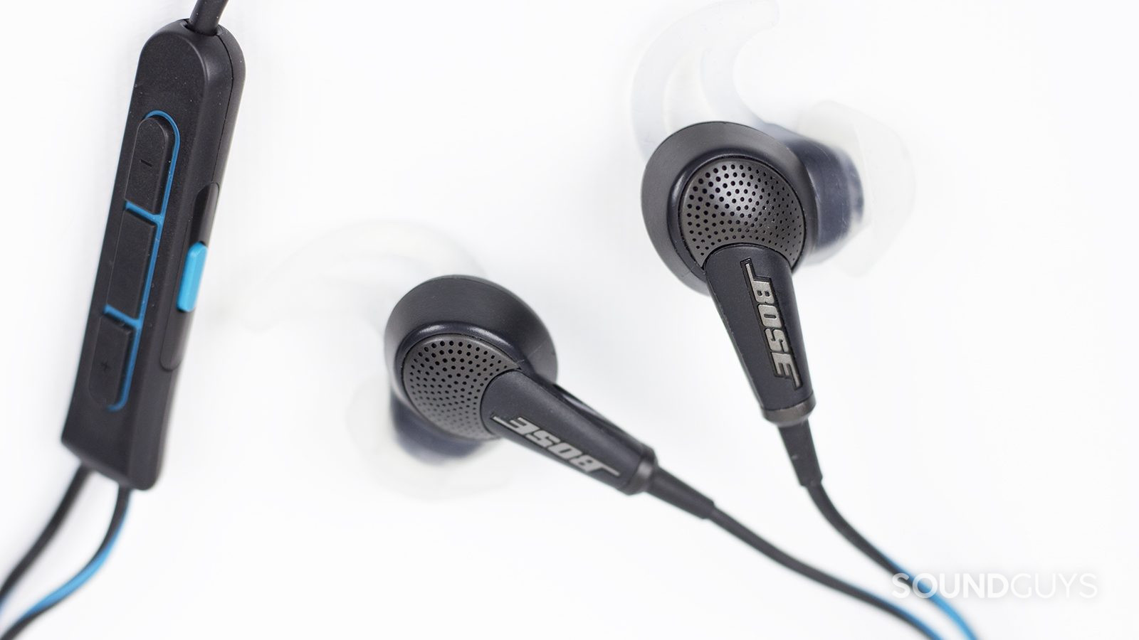 The Bose QuietComfort 20 noise canceling earbuds and mic module on white background.