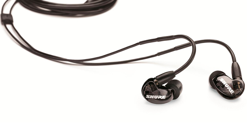 Thanks to the sound isolating design, the Shure SE215 are able to passively block up to 37 dB of ambient noise. Pictured: The Shure SE215 with the cable formed into a hook while the rest of it is coiled in the background.