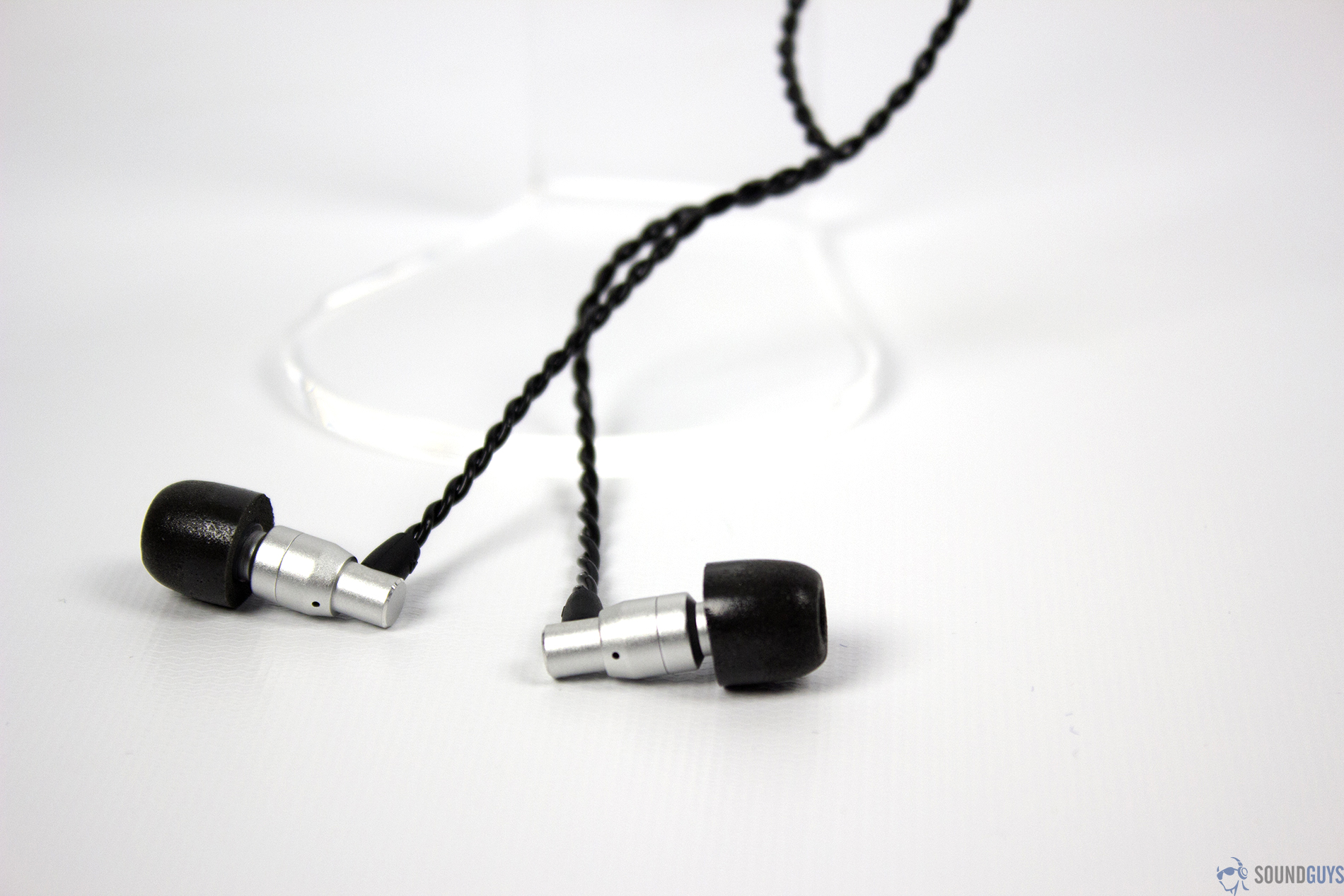 The ADV.SoundM4 earbuds on a white background with the braided cable overlapping itself.