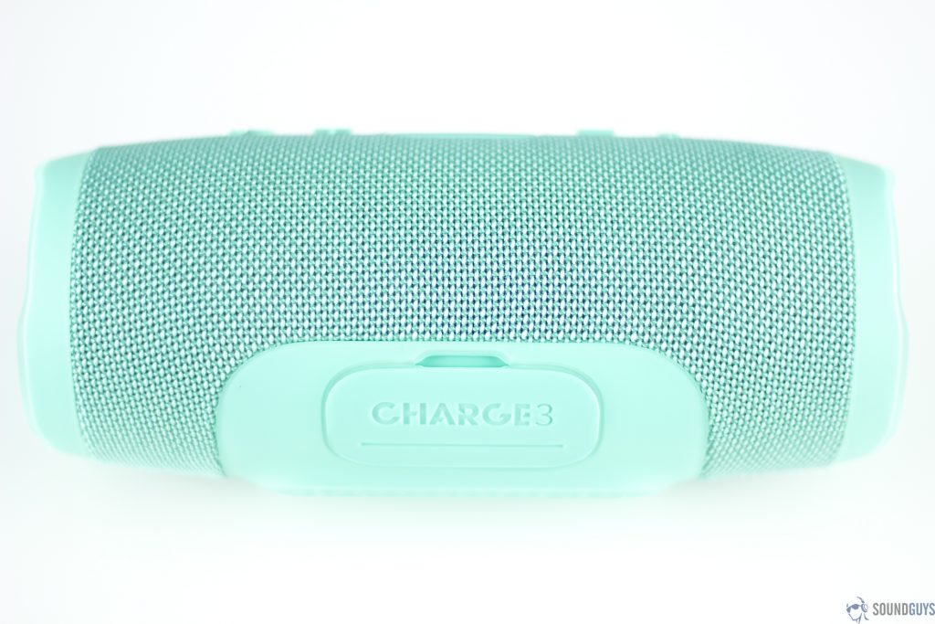 Pictured is the teal JBL Charge 3 Bluetooth speaker on its side showing the flap protecting the ports.