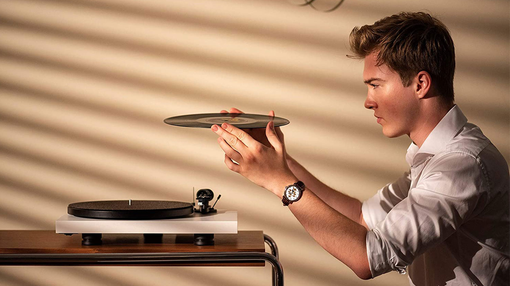 A man uses the Pro-Ject Debut Carbon EVO turntable.
