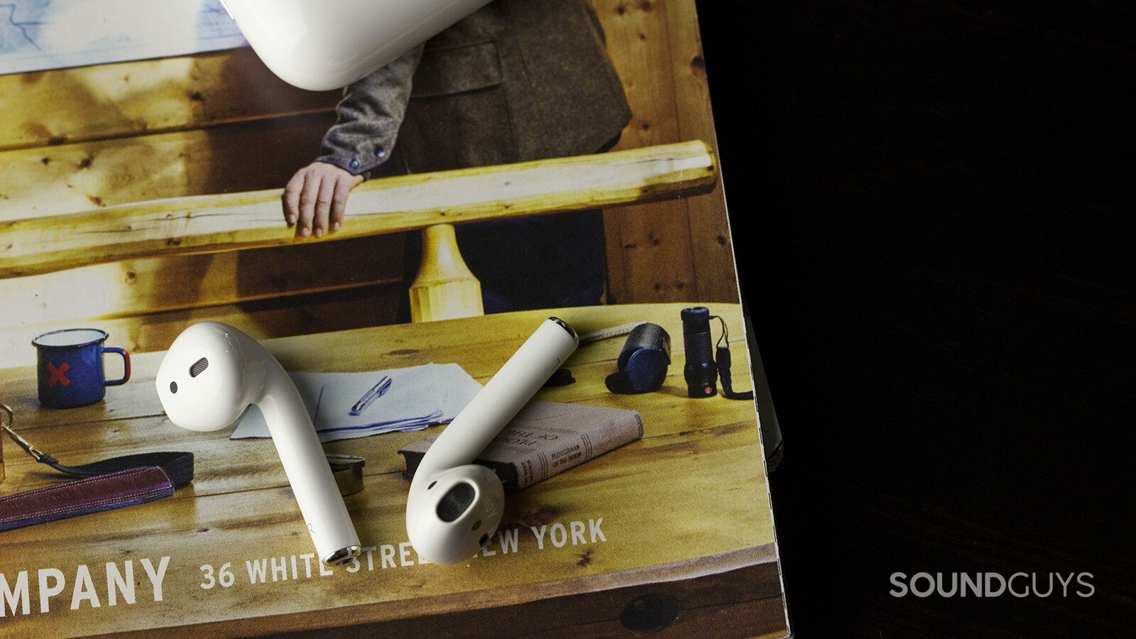 The Apple Airpods are easy to connect, if they're connecting to an iOS device. Android-users will have a more fraught time. Pictured: Apple Earpods laid on a magazine page with the small carrying case at the top portion of the image.