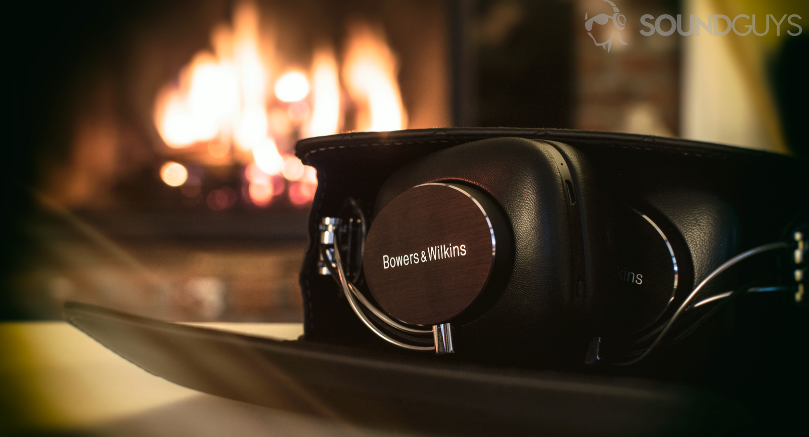A photo of the Bowers and Wilkins P7 Wireless inside its case, in front of a fire.