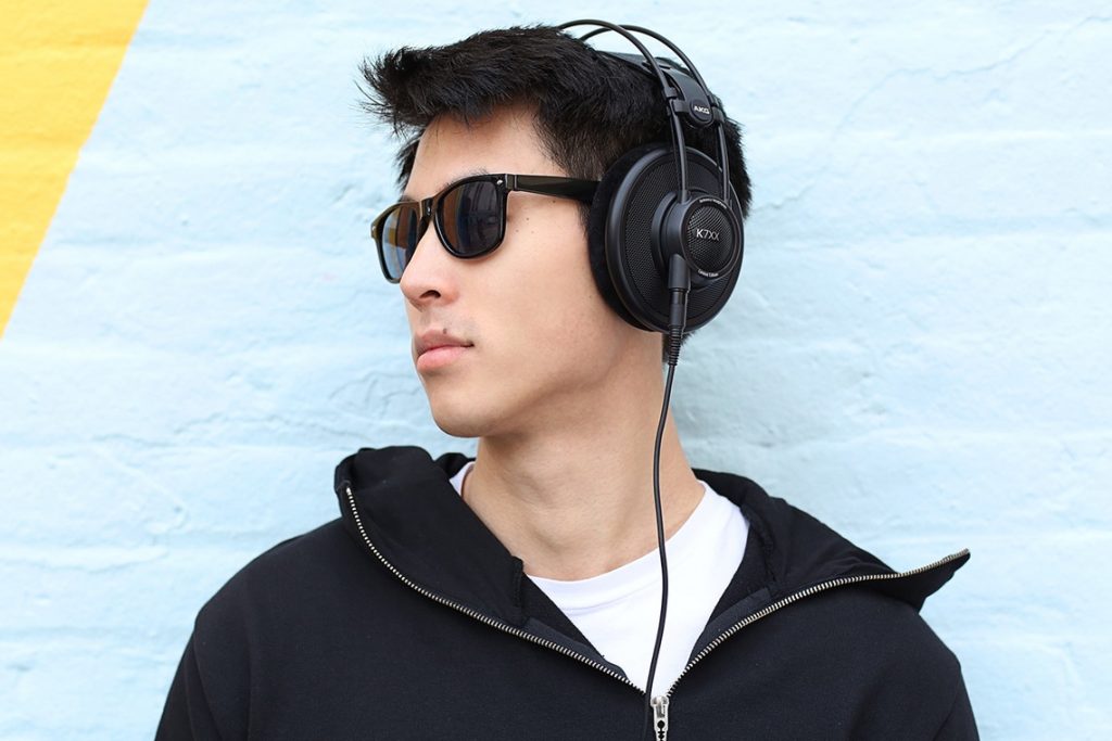 A photo of a person wearing the AKG K7XX headphones in an alleyway.