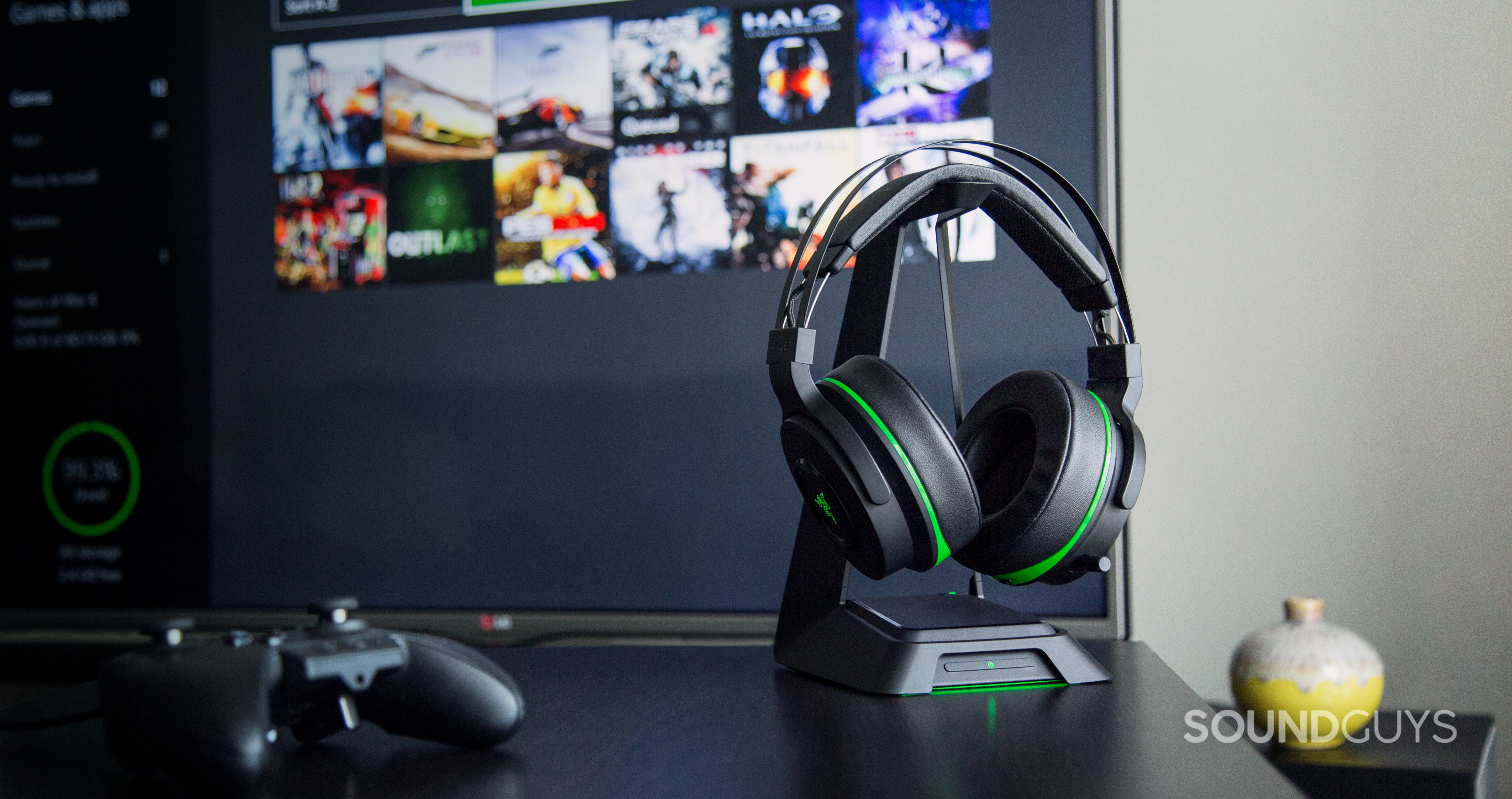 The Razer Thresher headphone pictured alongside an xbox-one and TV.
