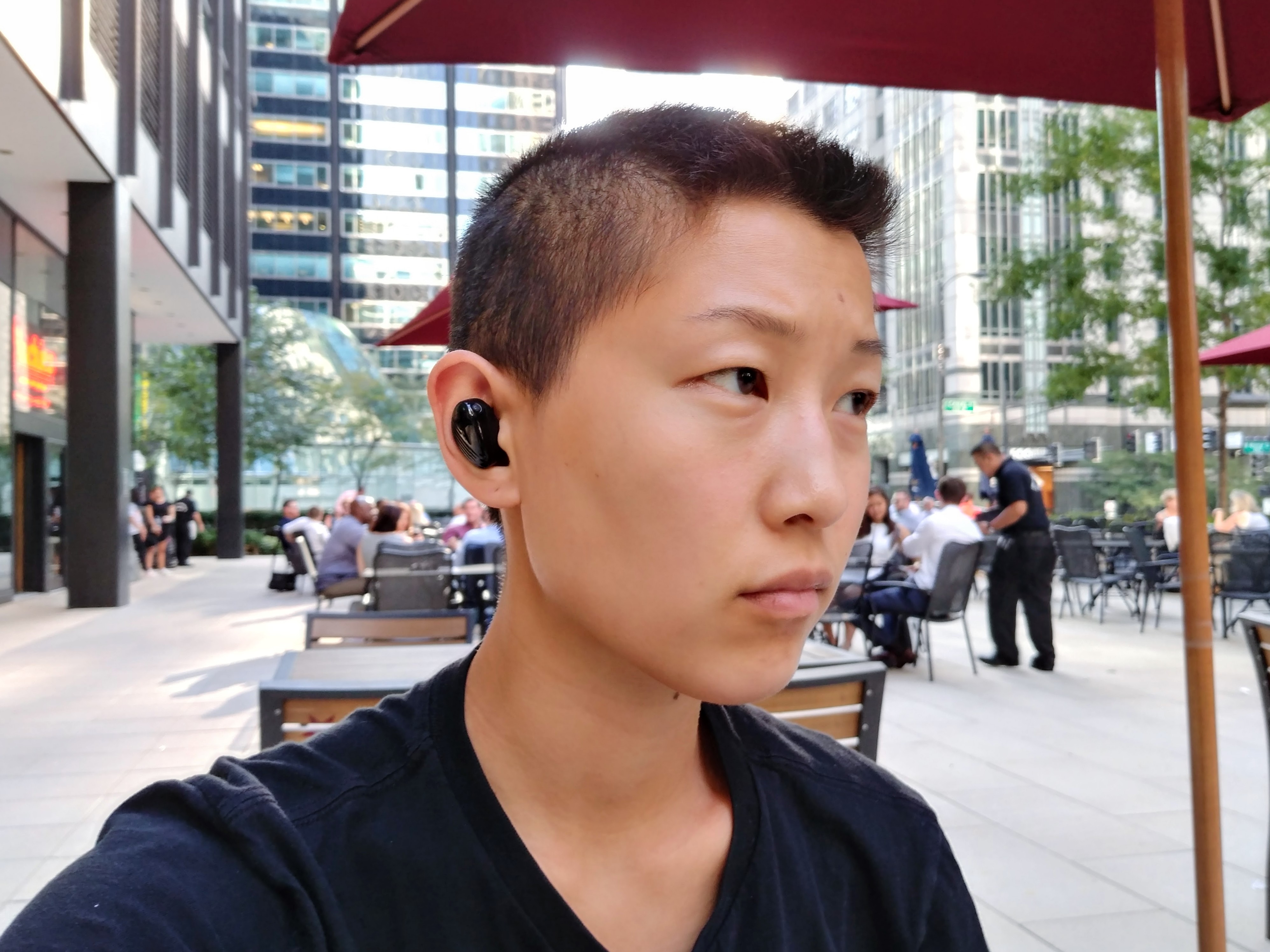 A photo of a woman wearing wireless Bluetooth earbuds.