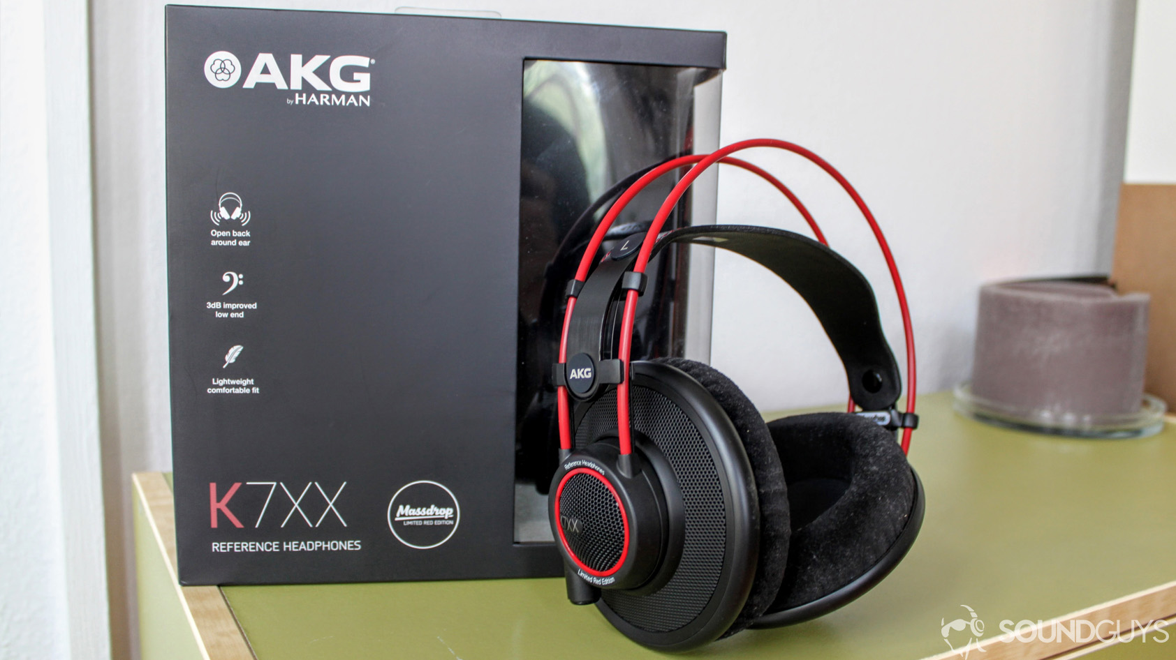 A photo of the AKG K7XX headphones and the packaging on a green desk. 