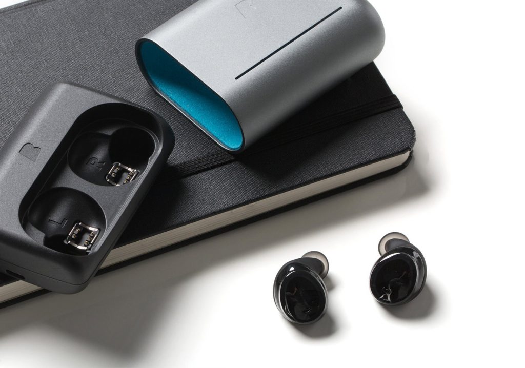 best waterproof headphones: Bragi Dash Pro on a white background near a sketchbook.