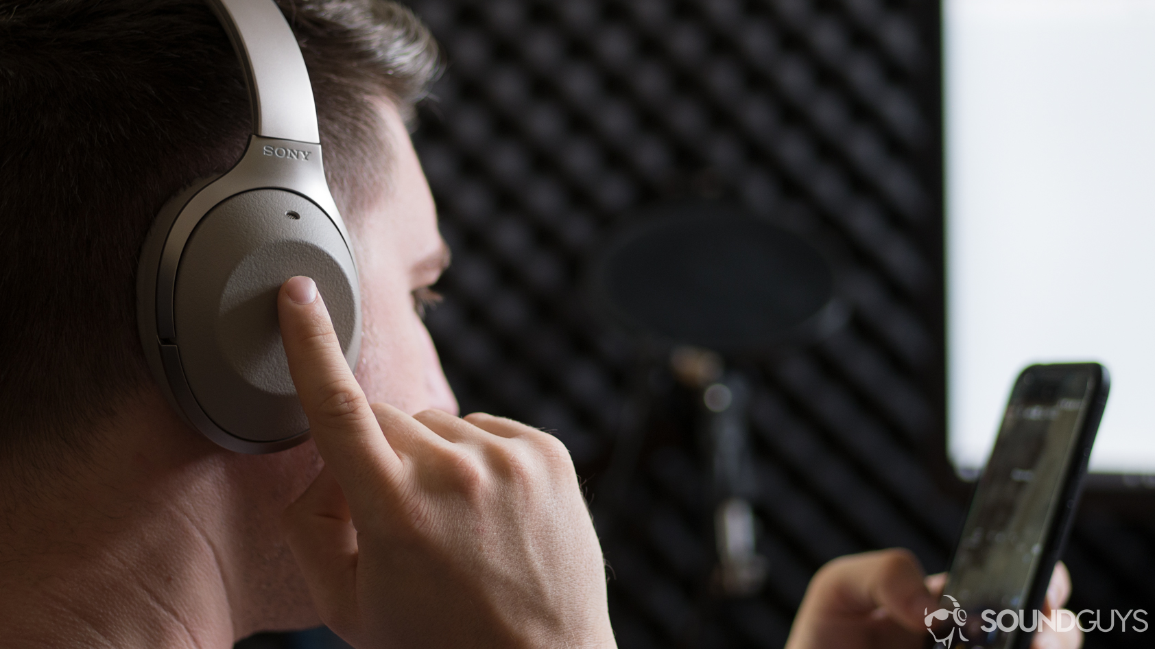 A photo of the Sony WH-1000X M2 wireless Bluetooth headphones being used to activate the Google Assistant on a Google Pixel XL.