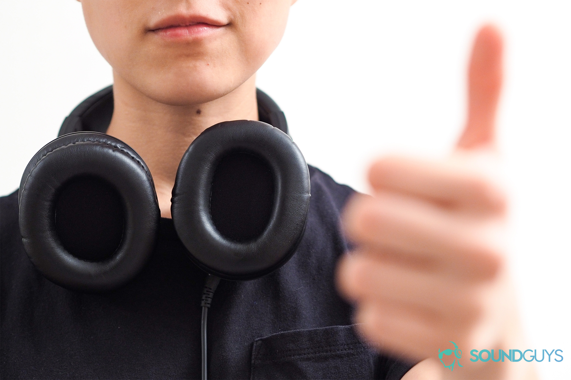 A photo of Lily Katz wearing Audio-Technica headphones, giving the thumbs-up.