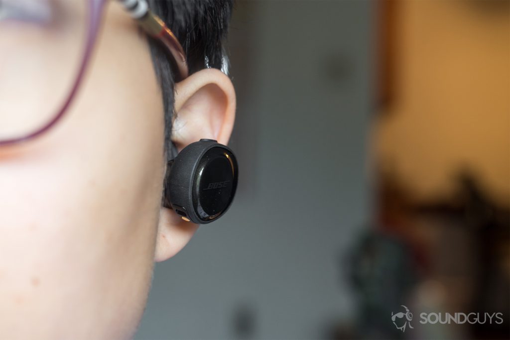 A picture of the Bose SoundSport Free housing is larger than the SoundSport Wireless housing, which was already large to begin with. Pictured: The left earbud of the Bose SoundSport Free placed in the left ear to illustrate its unusually large size.