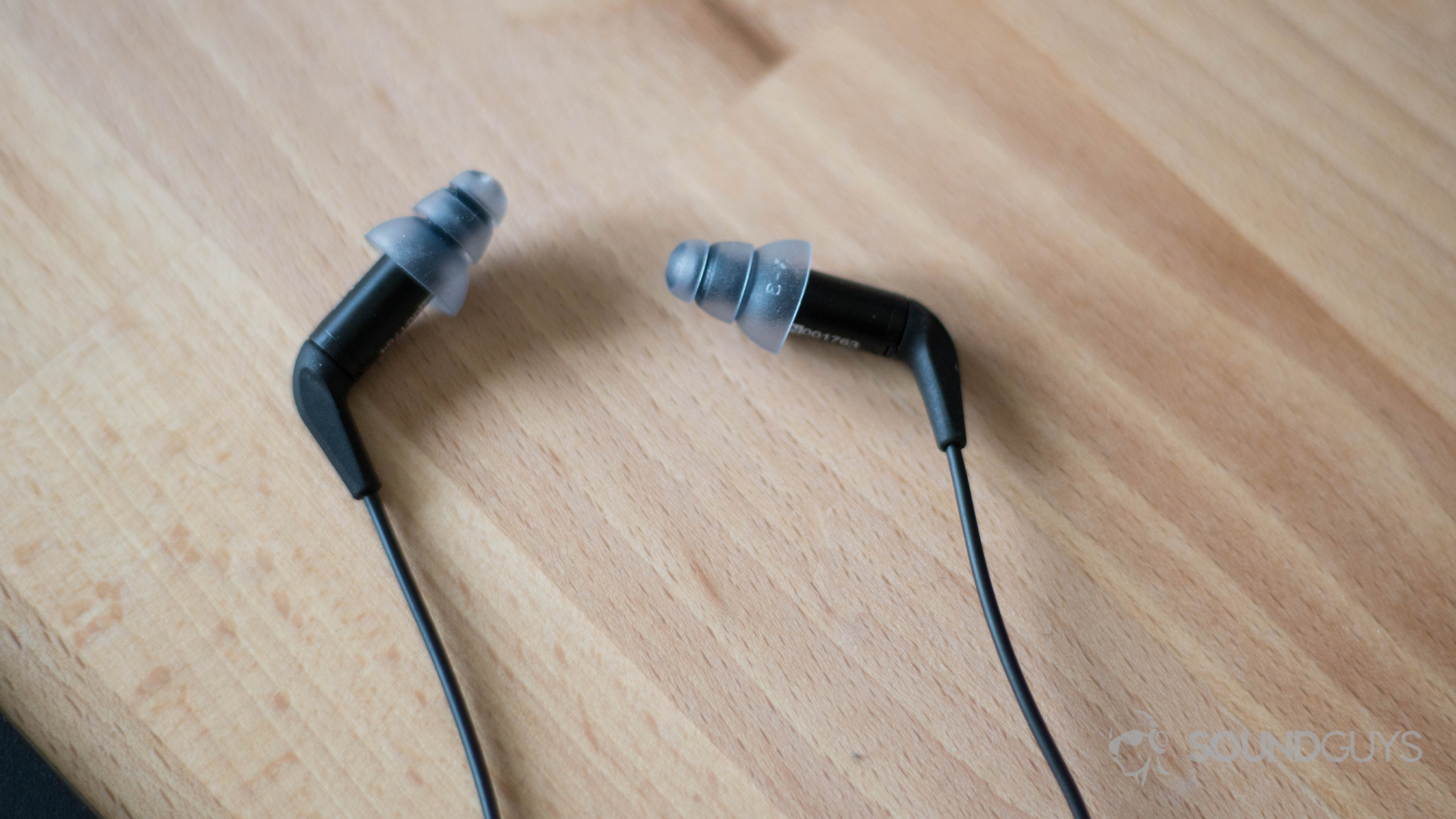 The Etymotic ER3XR IEMs in black on a wooden table.