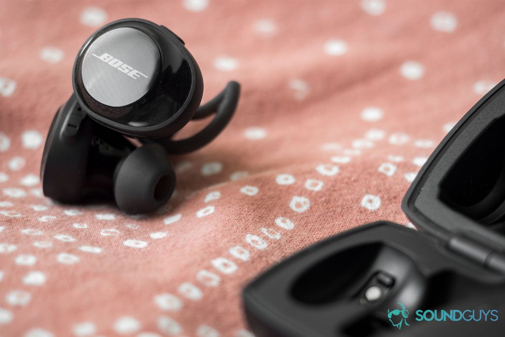 The low-end of the SoundSport Free signature is loud but unable to maintain a solid "thump." Pictured: The Bose SoundSport Free earbuds, which are stacked on top of each other and beside the open charging case.