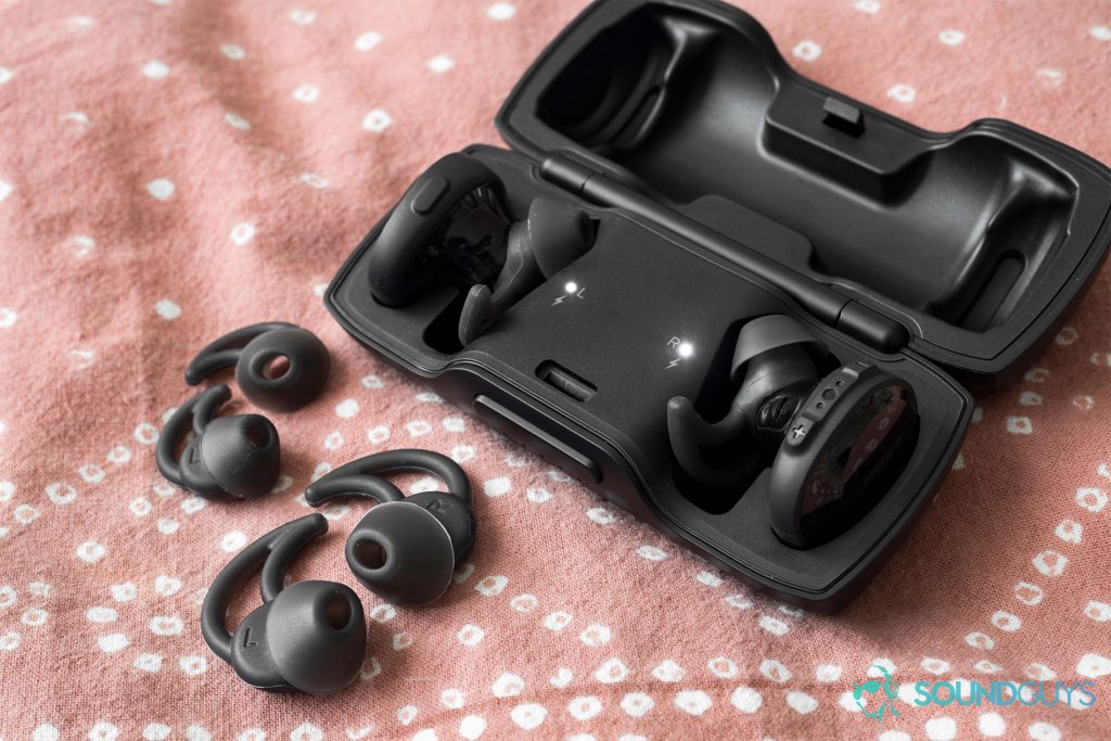 finding the right ear tips: Aside from the standard medium-sized StayHear+ ear tips, Bose provides small and large options too. Pictured: The Bose SoundSport Free earbuds docked in the case with the alternative ear tips (small, medium) laid out beside the case.
