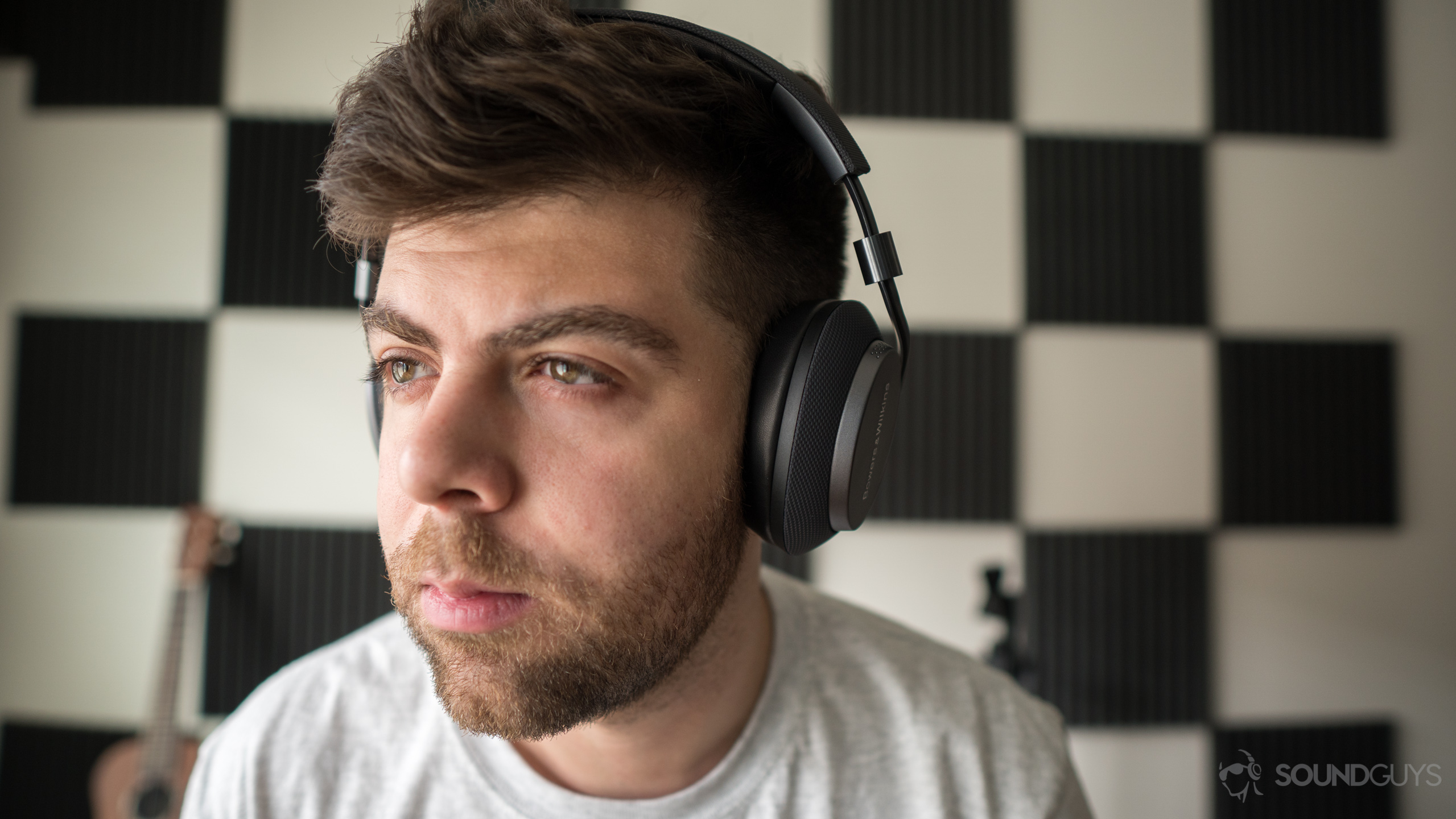 A photo of a man hearing wireless Bluetooth headphones, the Bowers &amp; Wilkins PX.