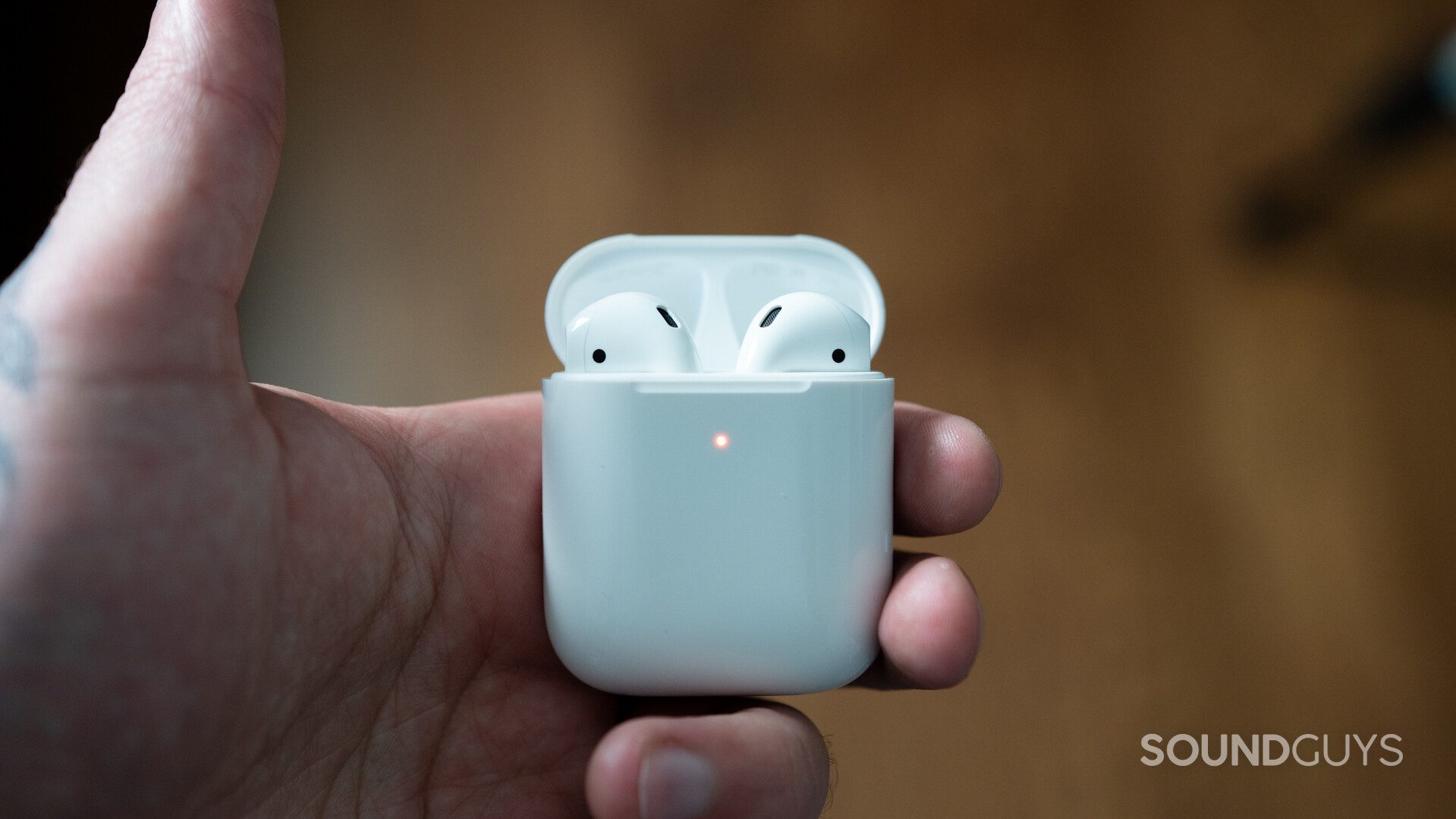 Pictured is the new Airpods changing case in hand for a comparison in the Apple AirPods vs Samsung Galaxy Buds Live breakdown.