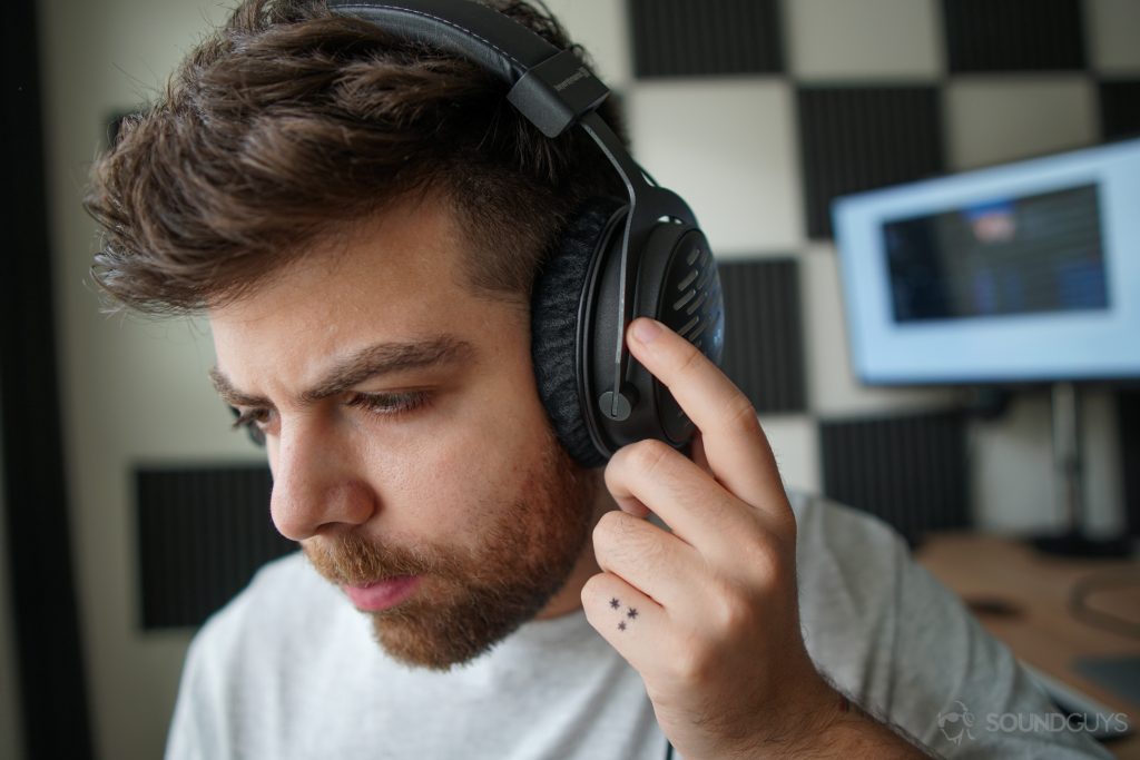 A photo of a man listening to the Beyerdynamic DT 1990 Pro, with high-def equipment, including a DAC