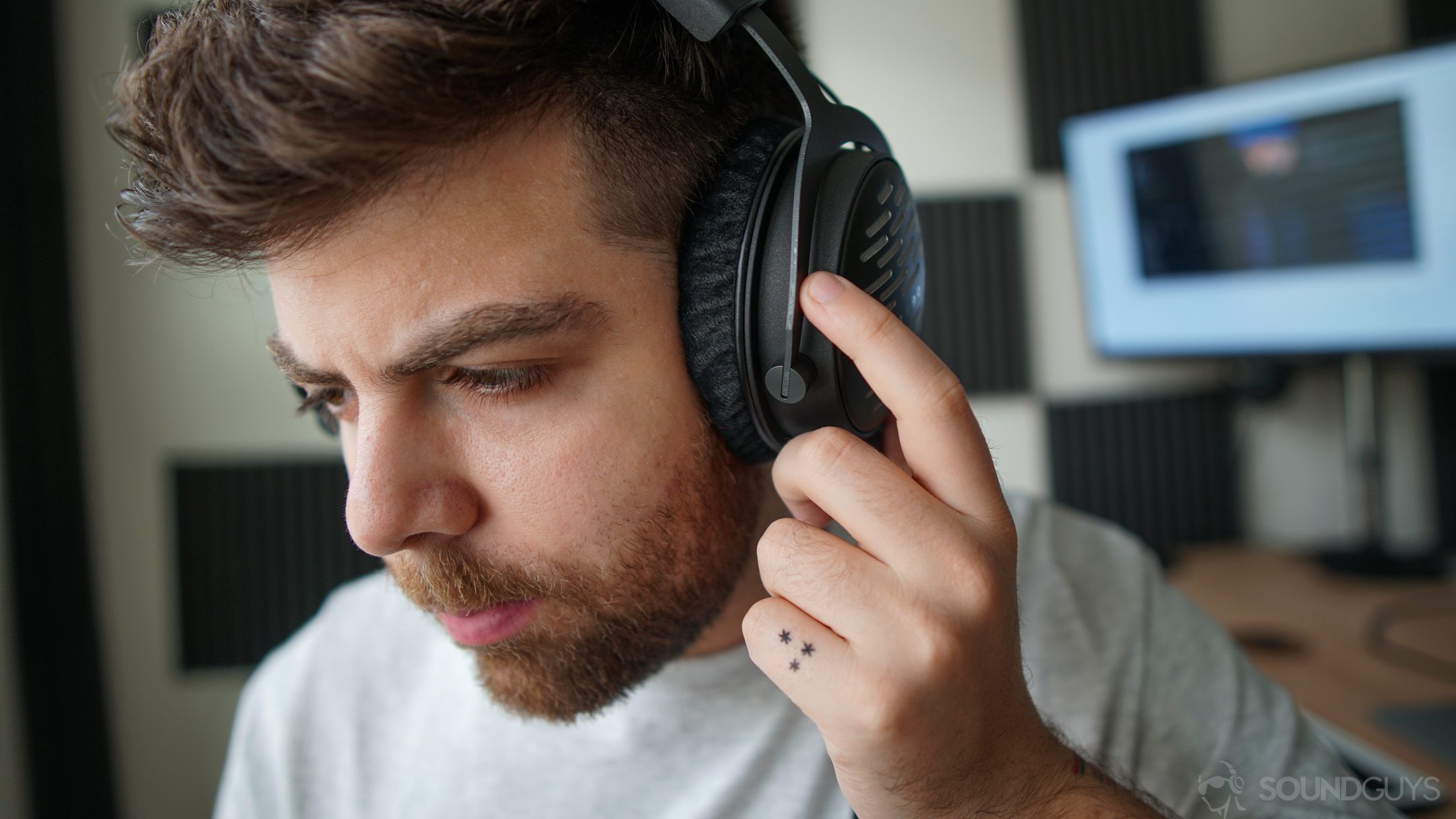A photo of a man listening to the Beyerdynamic DT 1990 Pro, with high-def equipment, including a DAC