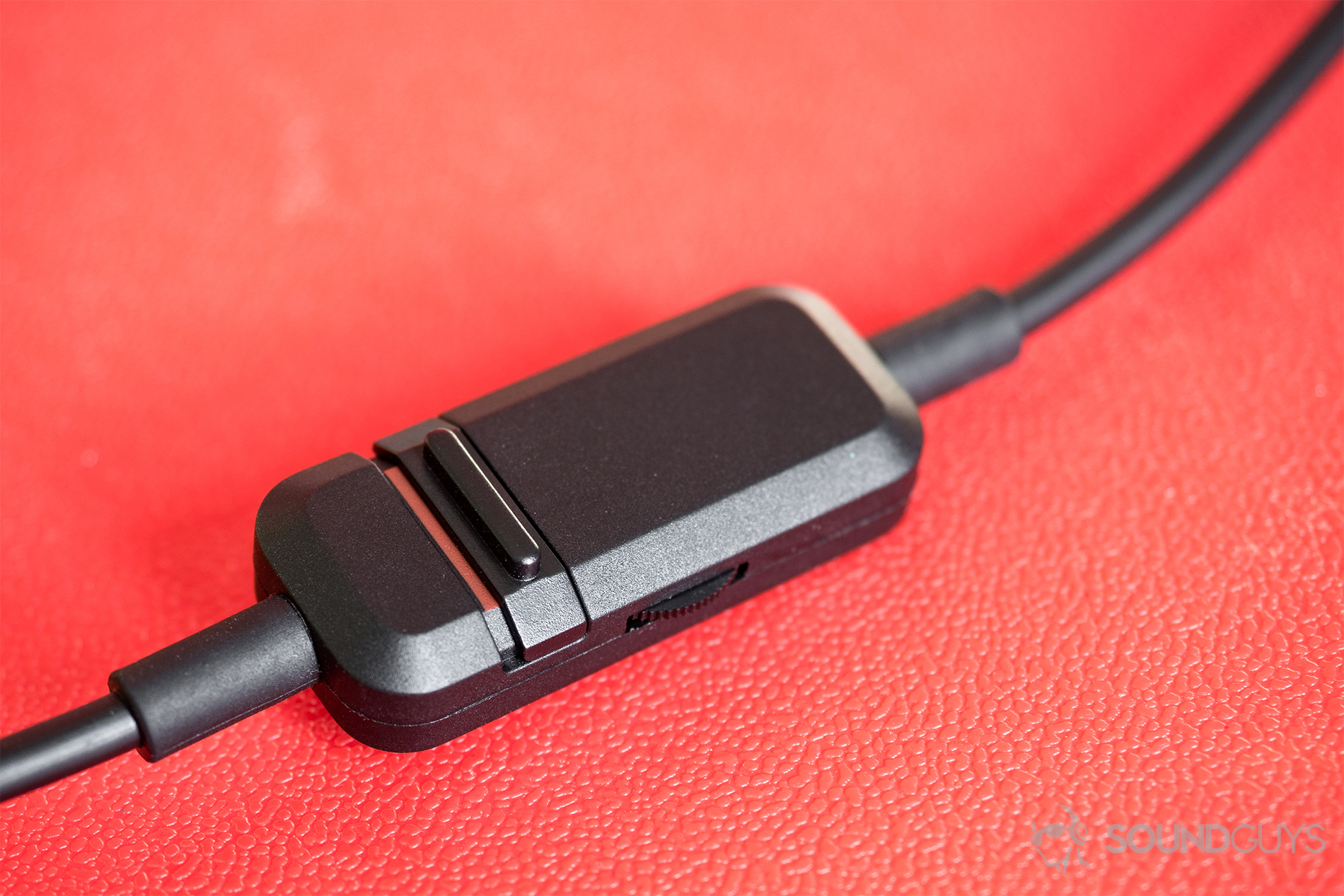 Beyerdyanamic CUSTOM Game: A close-up of the in-line remote/mic on a red background.