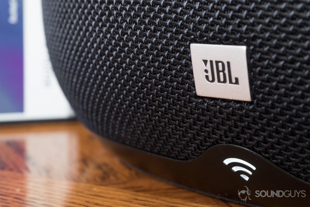 JBL Link 300 Google Assistant-integrated smart speaker: A close-up of the smart speaker. Depicted is the LED indicator and minimal branding of the JBL logo, which is about a 0.5 x 0.5 inch-square.