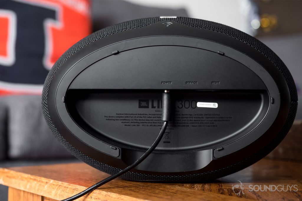 JBL Link 300 Google Assistant-integrated smart speaker:The bottom of the JBL Link 300 with the power adapter extending from it.