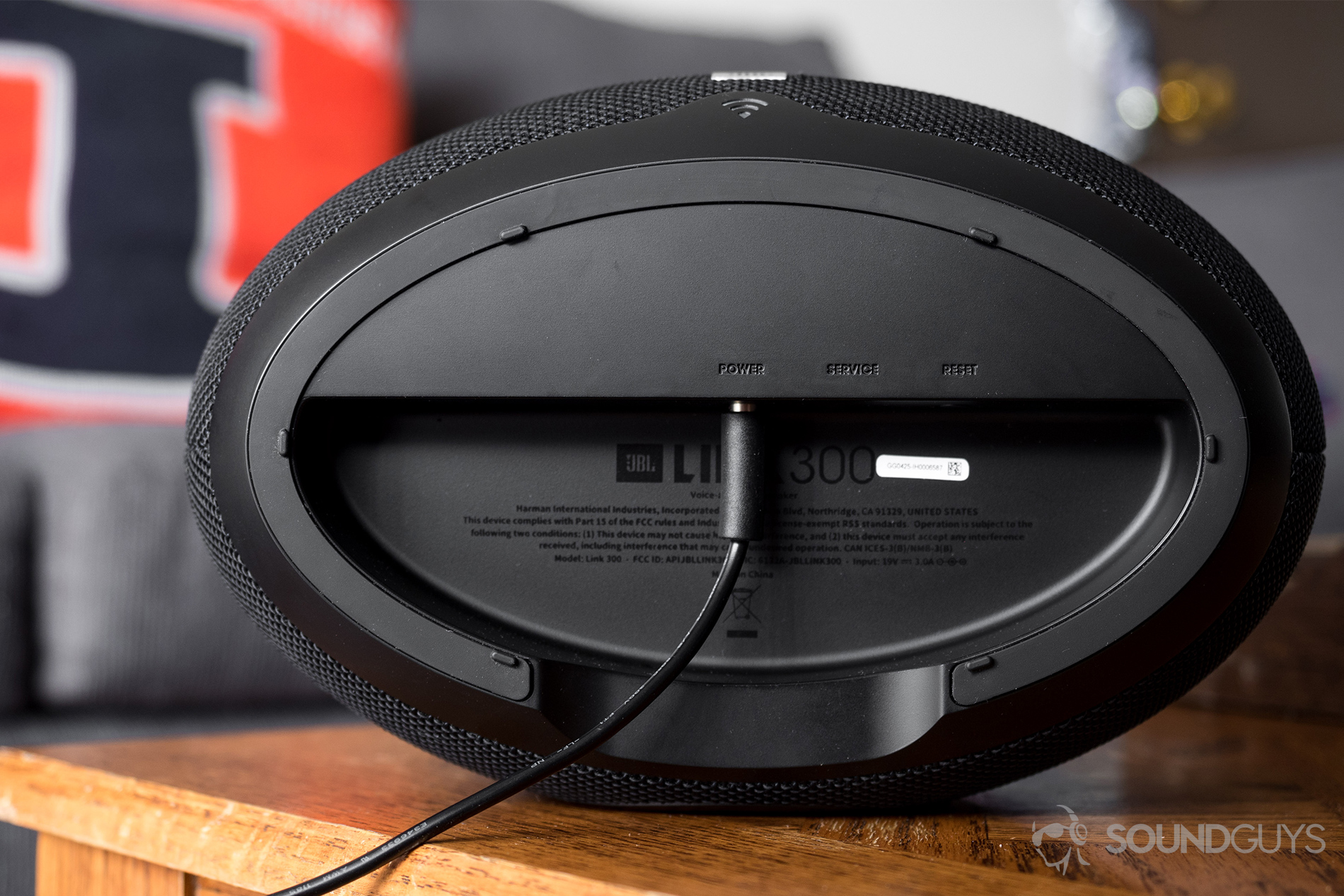 JBL_Link 300_LK_5 JBL Link 300 Google Assistant-integrated smart speaker:The bottom of the JBL Link 300 with the power adapter extending from it.