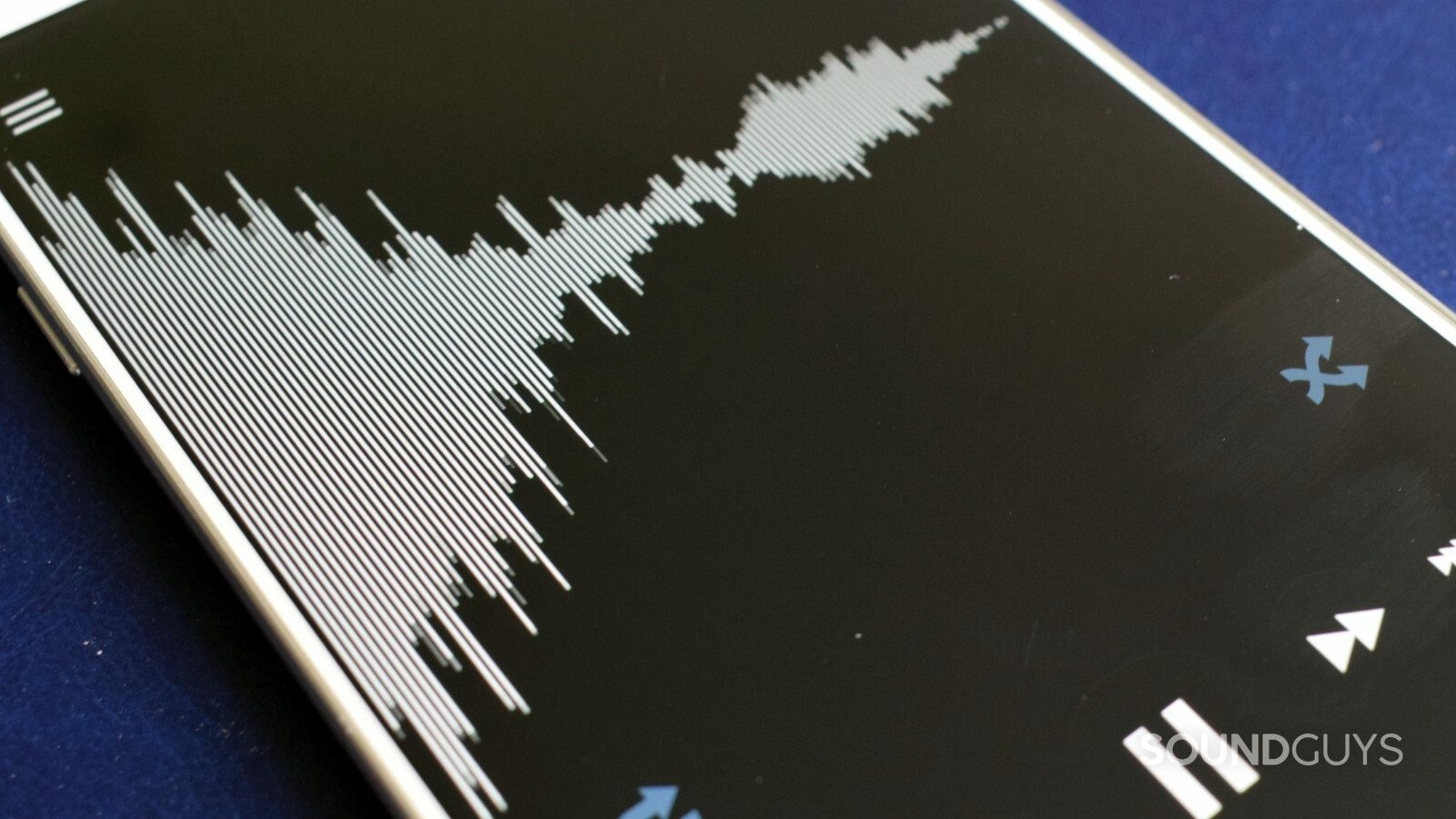 A photo of a phone displaying a waveform on its screen, with music playback controls at the bottom.