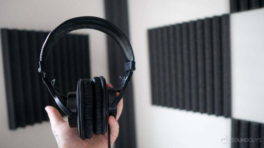 Holding up the MDR-7506 headphones to show the plastic build.