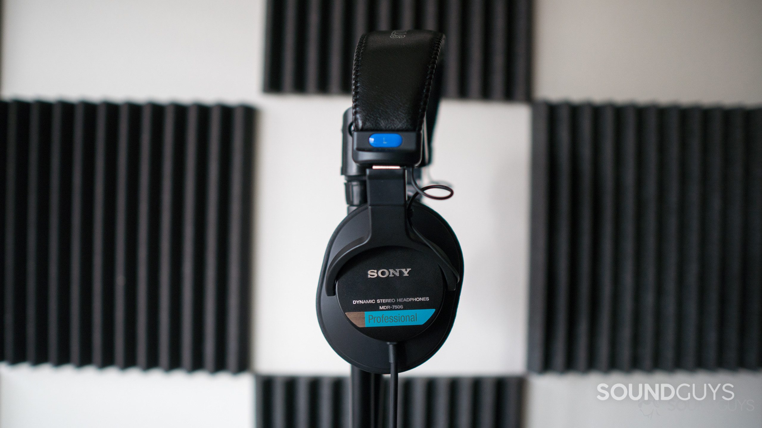 A picture of the Sony MDR 7506 resting on a microphone stand in a home studio recording room.