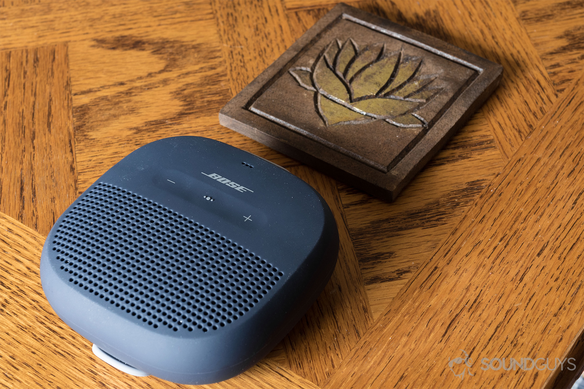 The Bose SoundLink Micro (blue) under a coster for scale.