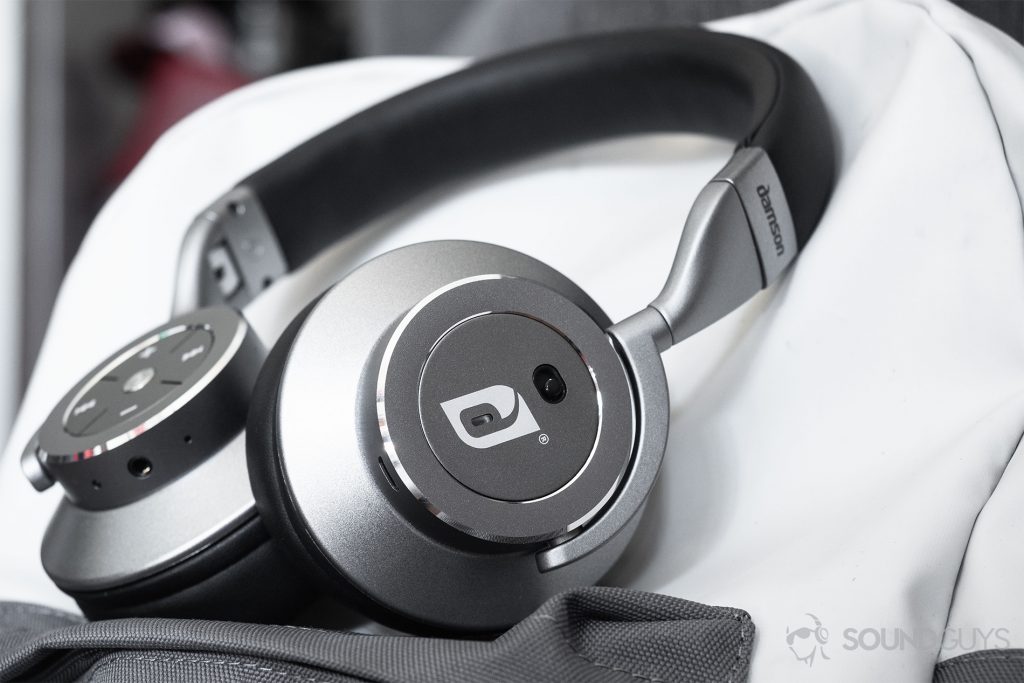 Damson HeadSpace Active Noise-Cancelling review: The headphones on a white and gray backpack. The active noise-cancelling toggle is facing the viewer.