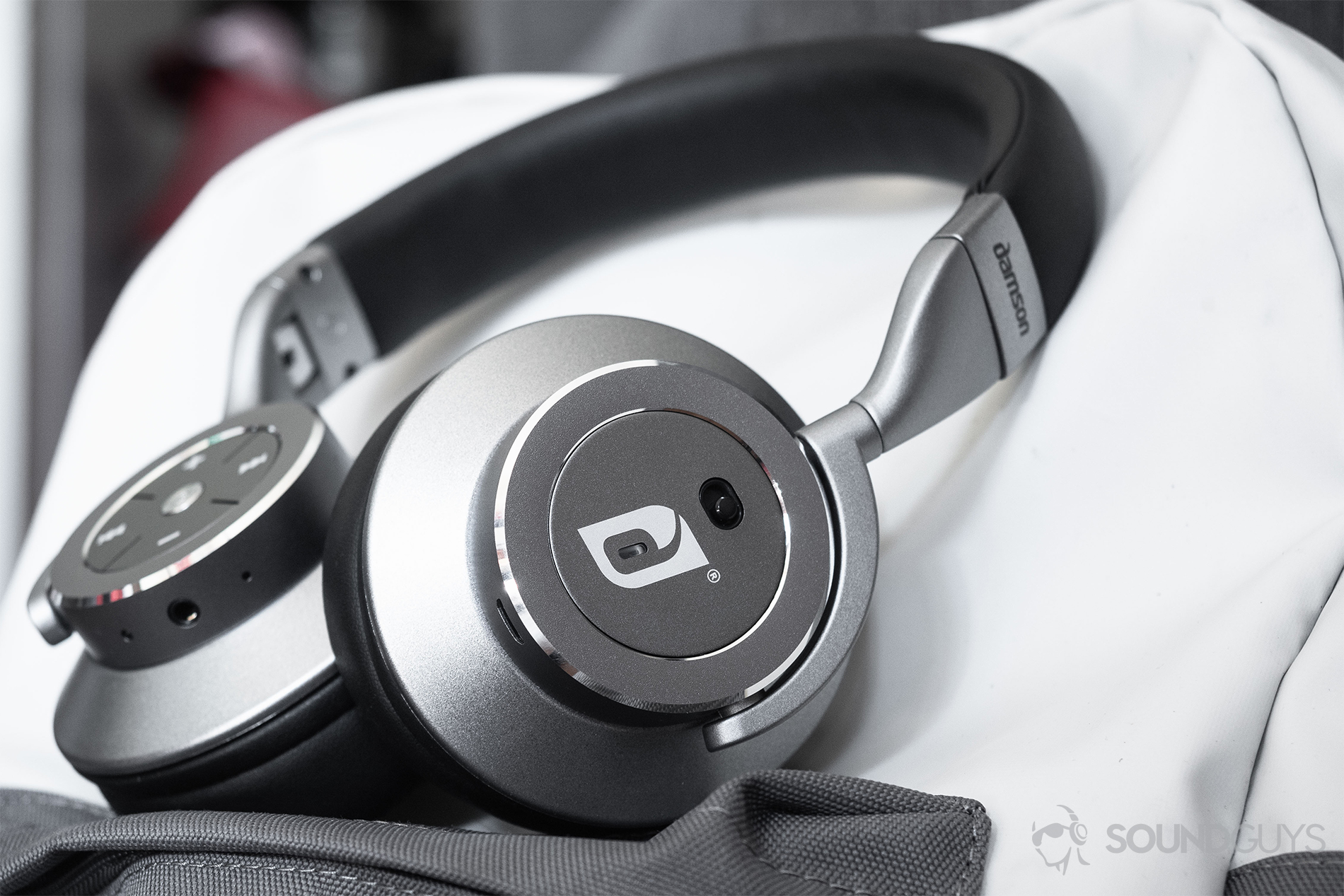 Damson_HeadSpace_LK_3 Damson HeadSpace Active Noise-Canceling review: The headphones on a white and gray backpack. The active noise-canceling toggle is facing the viewer.