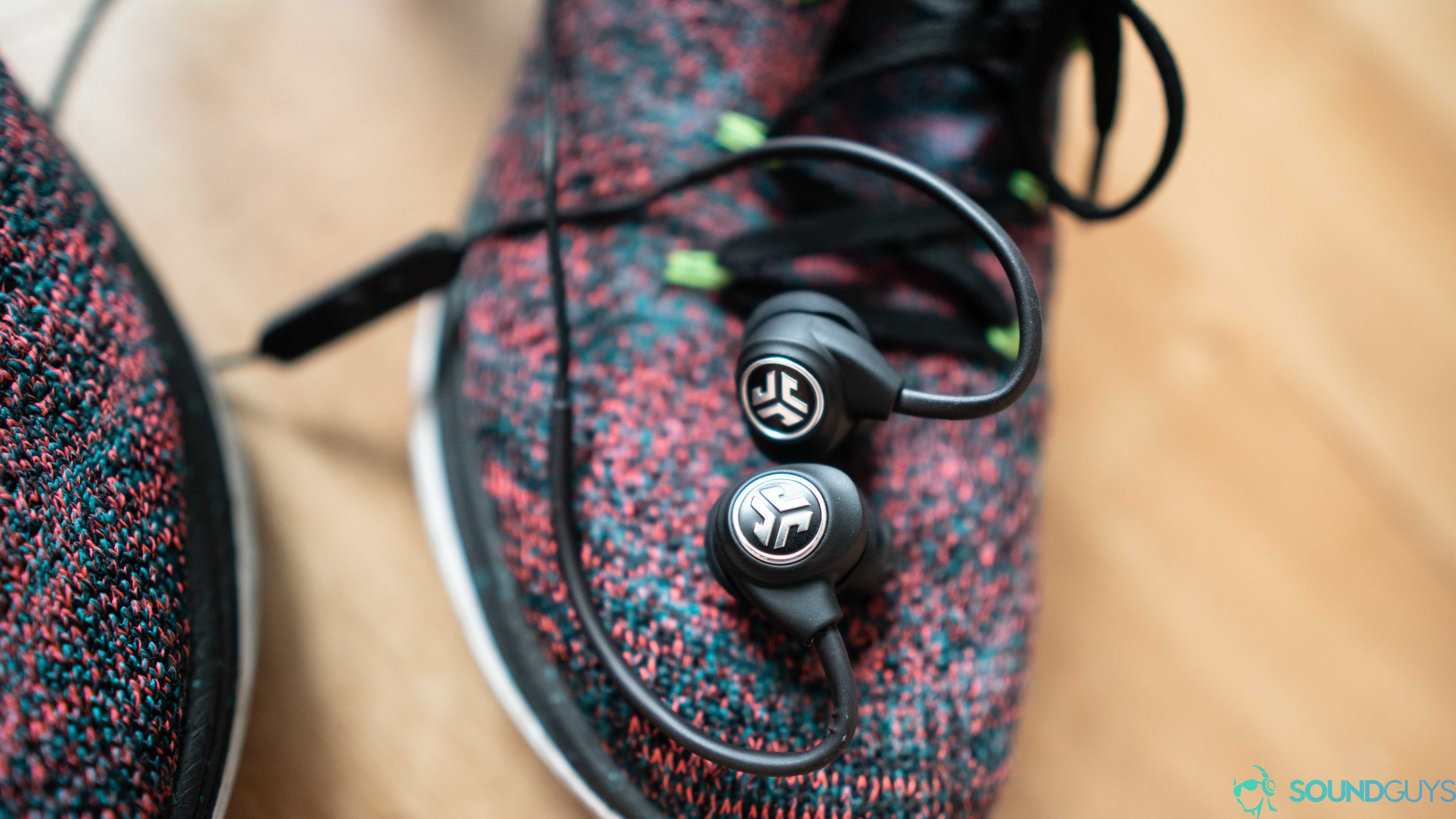 The earbuds on top of a pair of running sneakers