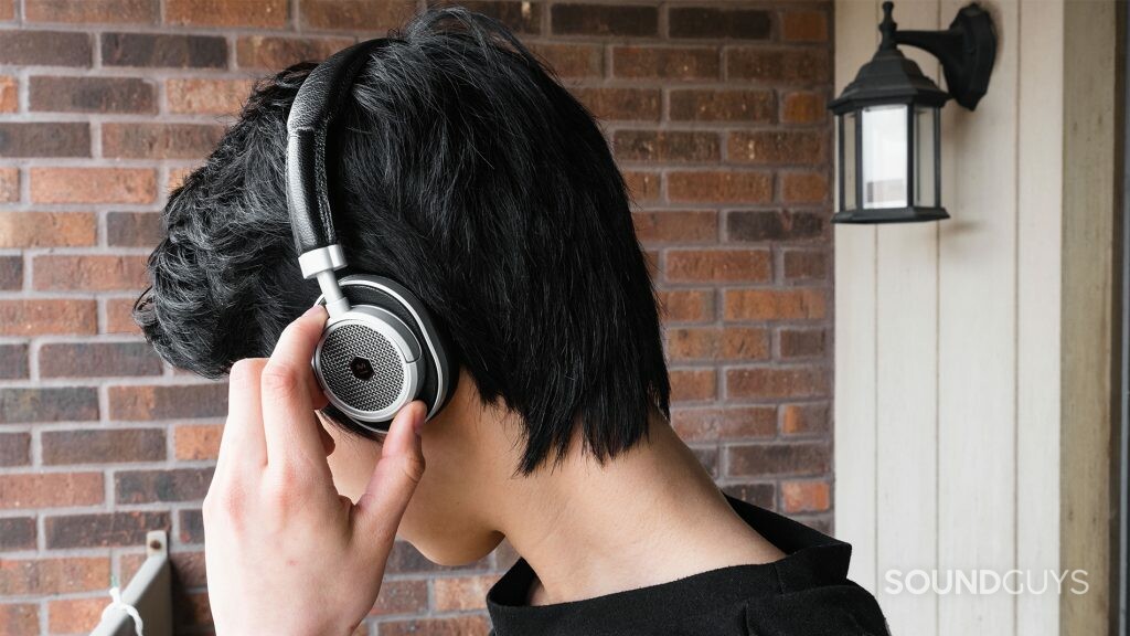 Master & Dynamic MW50 review: The headphones being worn while trying to use the small playback toggles.