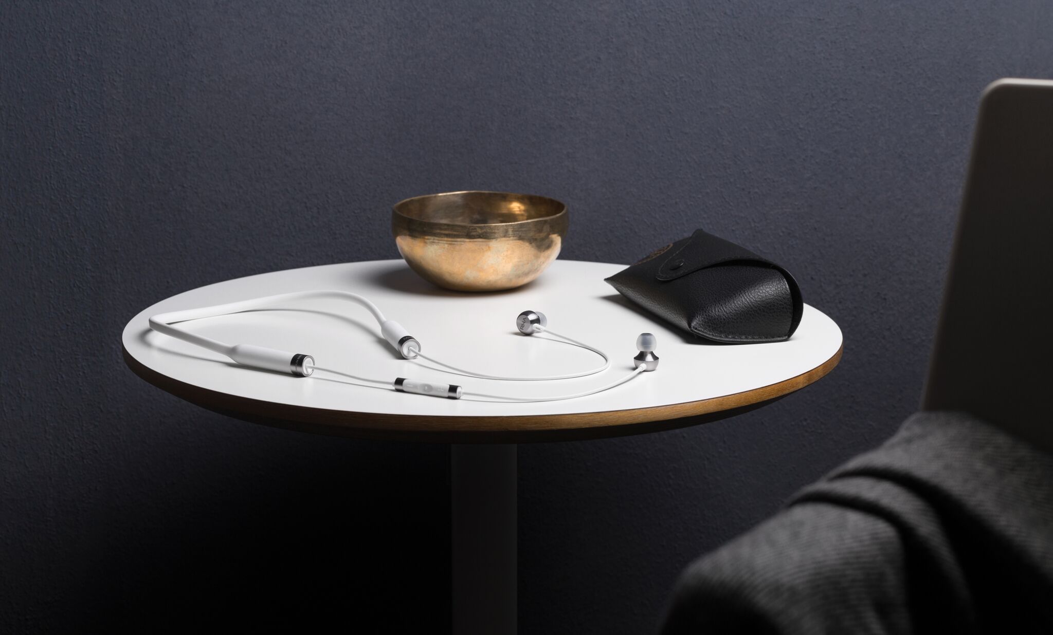 RHA MA650 Wireless in white on a white table with Ray-Ban glasses (case) and a gold decorative bowl.