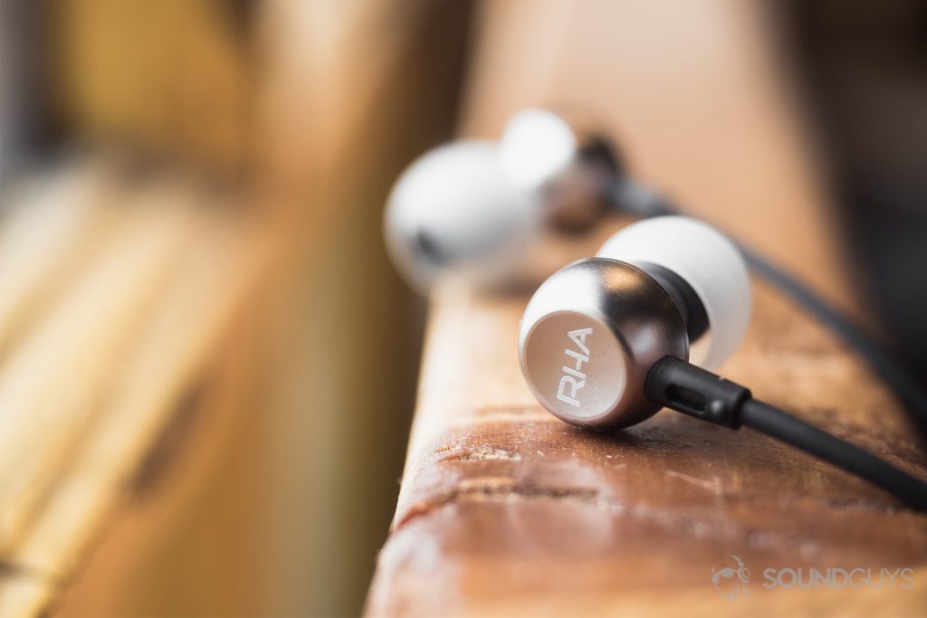 Best cheap bluetooth speakers: The earbuds are placed on a railing--the closer one is facing away from the user to show off the RHA logo and other is directed toward the viewer but is slightly blurred.