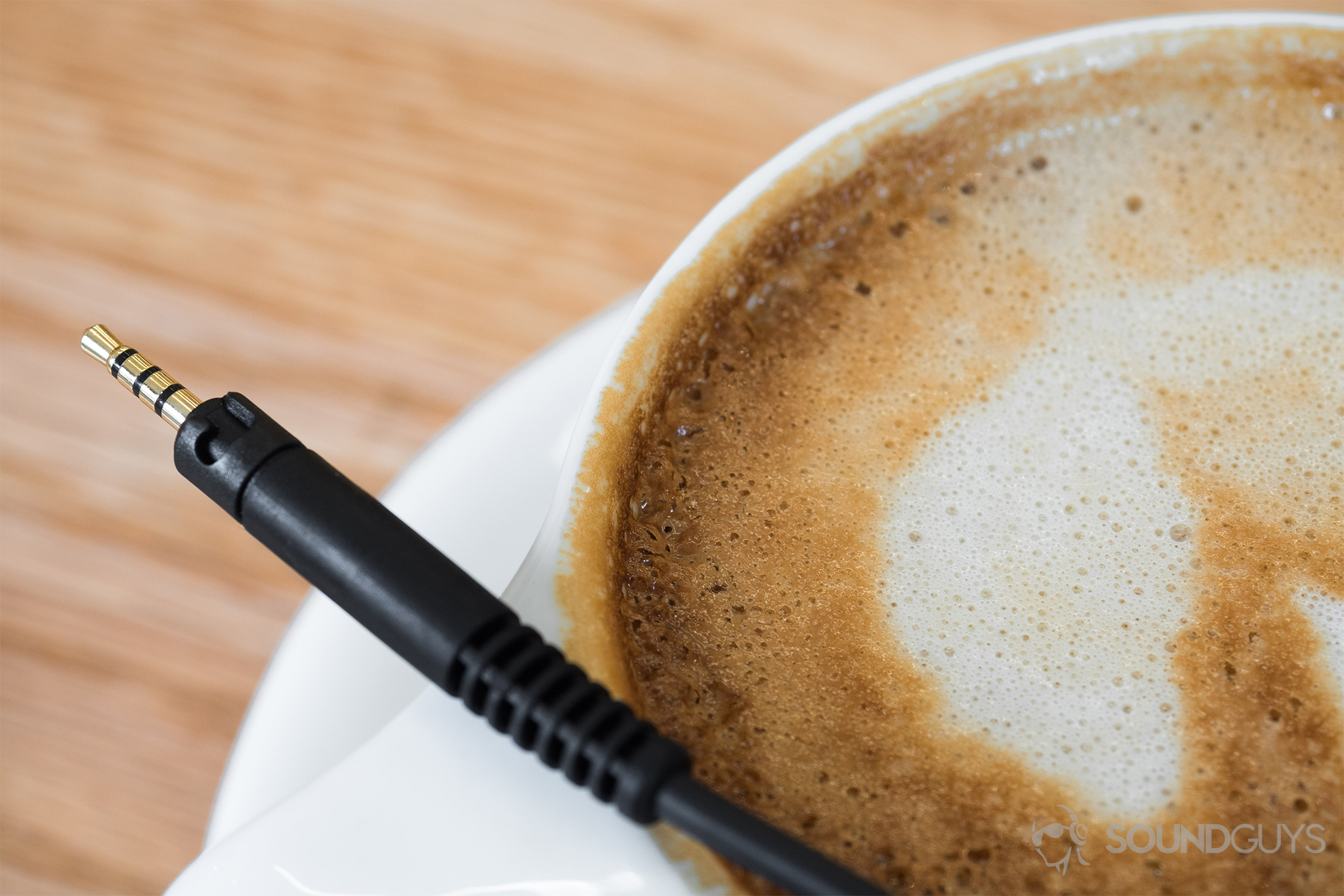 A close up of the Sennheiser HD 598 CS 2.5mm end of the cable on a cappuccino cup.