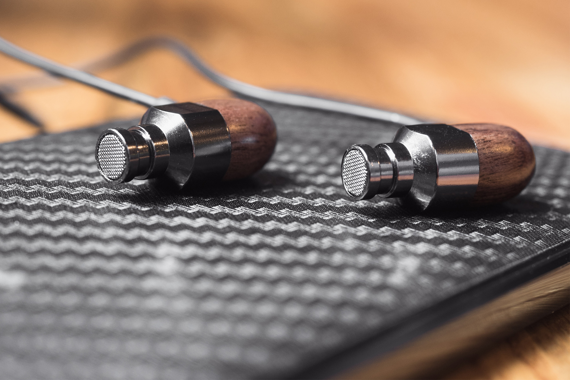 Thinksound ts03+mic review: The earbuds on a light-colored wood surface surrounded by an LG G6 in the background.