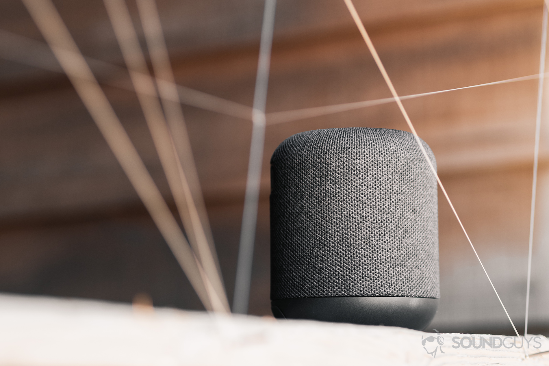 Anker Soundcore Motion Q review: An image of the speaker on a wood surface, against a horizontally paneled (wood) background.