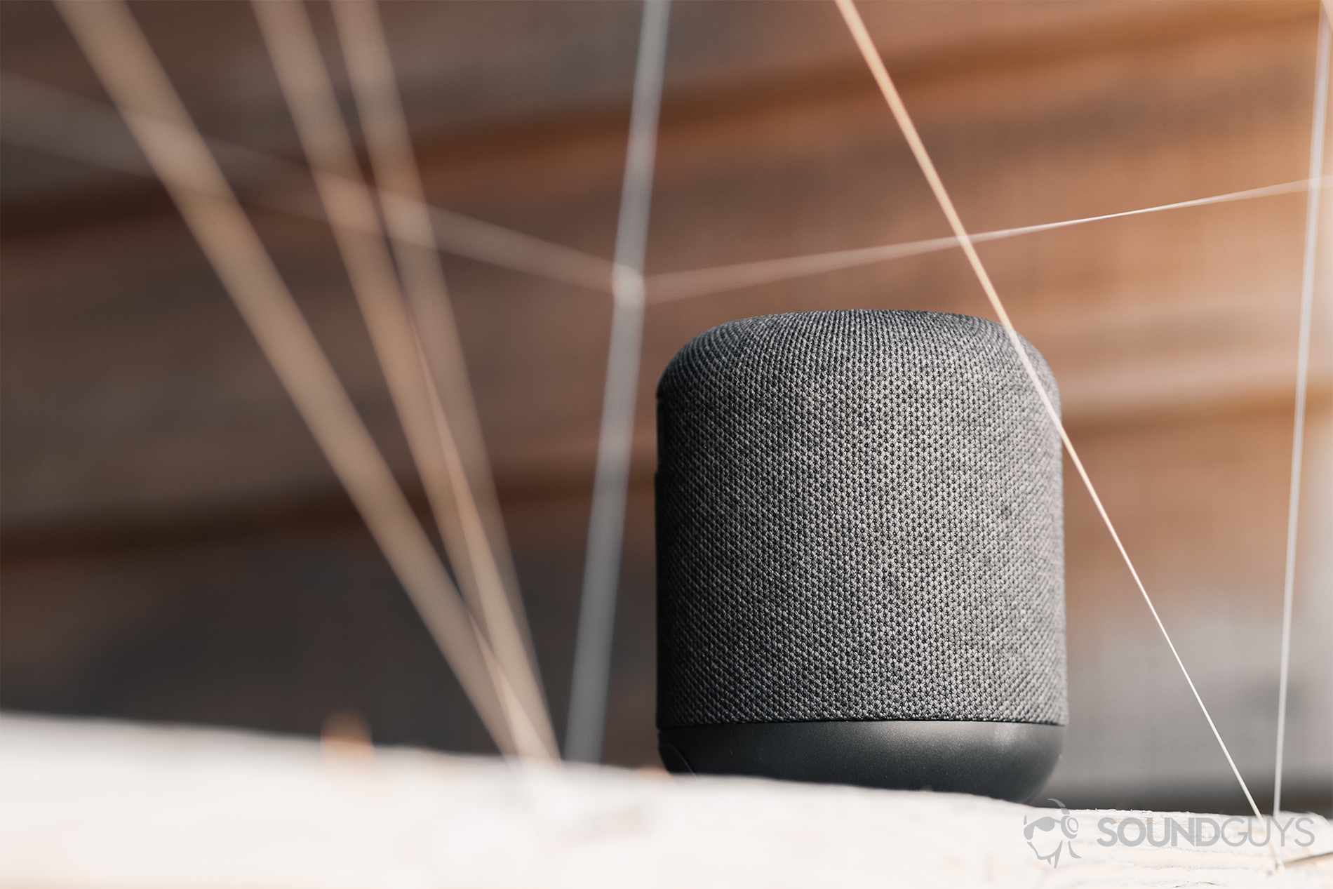 Anker_Motion Q_LK_1 Anker Soundcore Motion Q review: An image of the speaker on a wood surface, against a horizontally paneled (wood) background.
