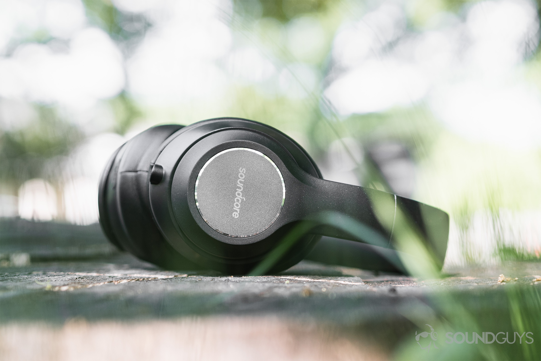 Anker Soundcore Vortex review: An &quot;ant's eye view&quot; of the headphones on a tree stump. 