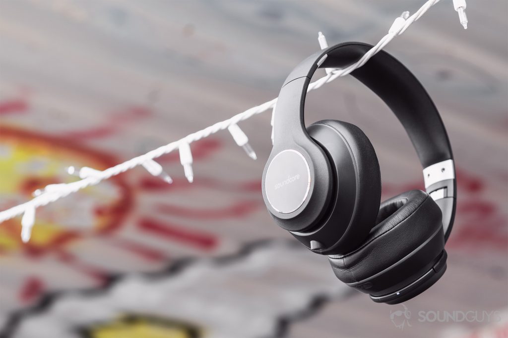 Anker Soundcore Vortex review: The headphones hanging from white string lights against a corrugated background.