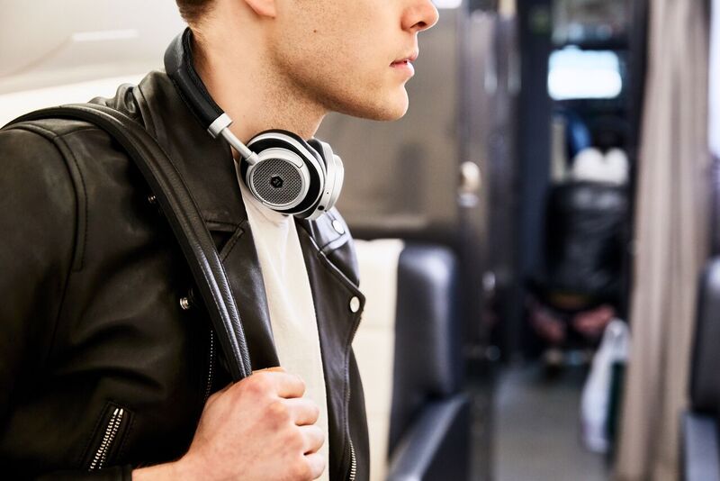 The Master &amp; Dynamic MW50+ Wireless worn around a man's neck. The headphones are in black.