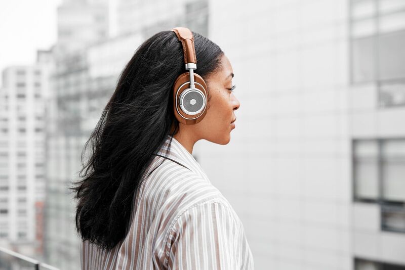Master & Dynamic MW50+: A woman wearing the MW50S2+ over-ear headphones in brown.