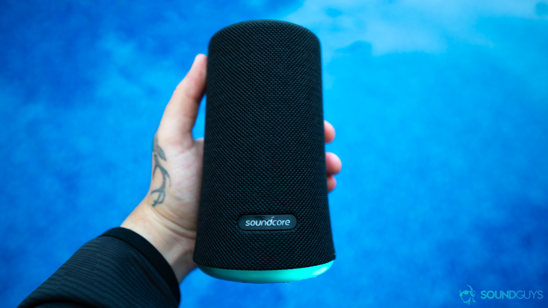 Holding the Soundcore Flare over the pool.
