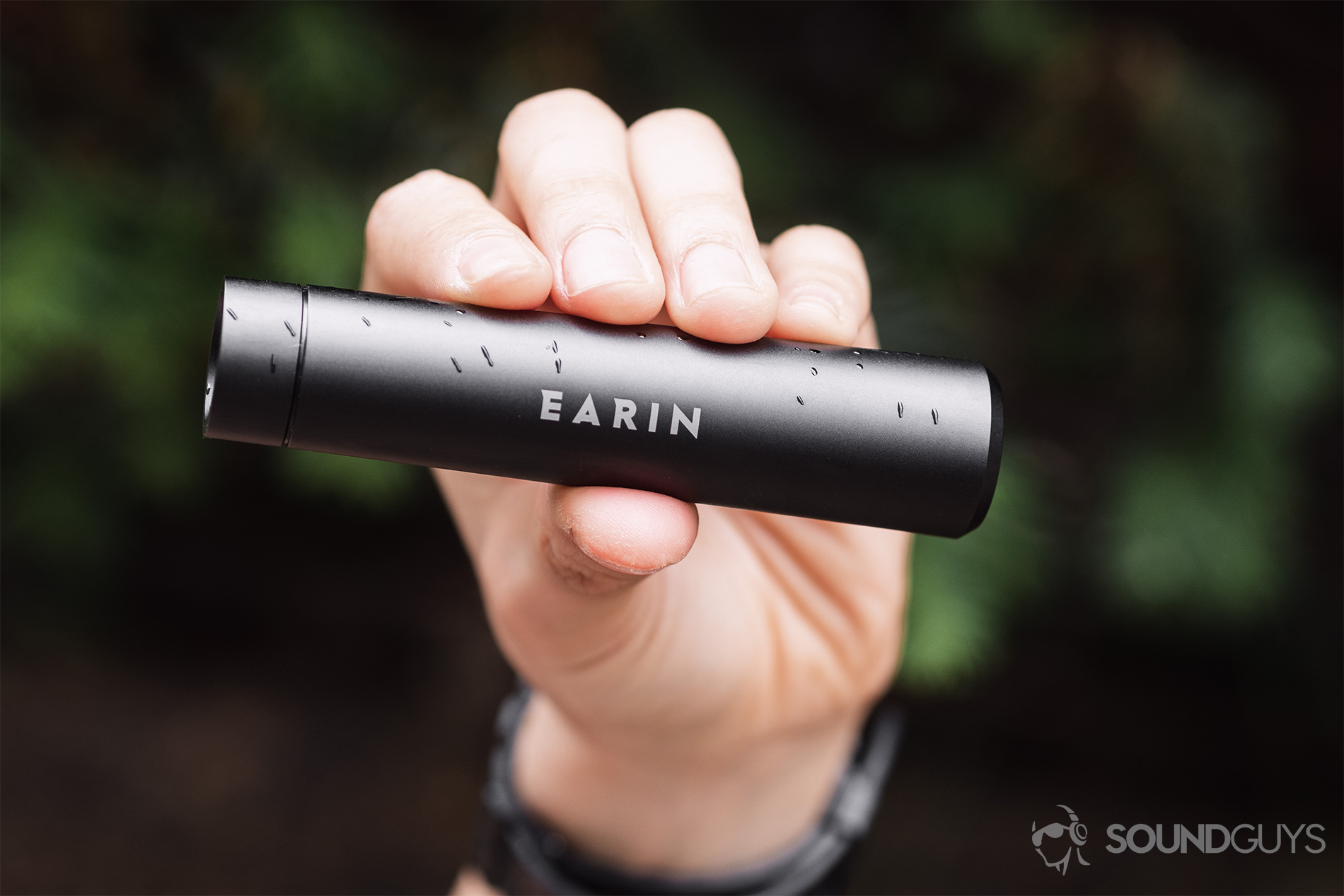 Earin M-2 review: Portable charging capsule in the hand with rain on it.