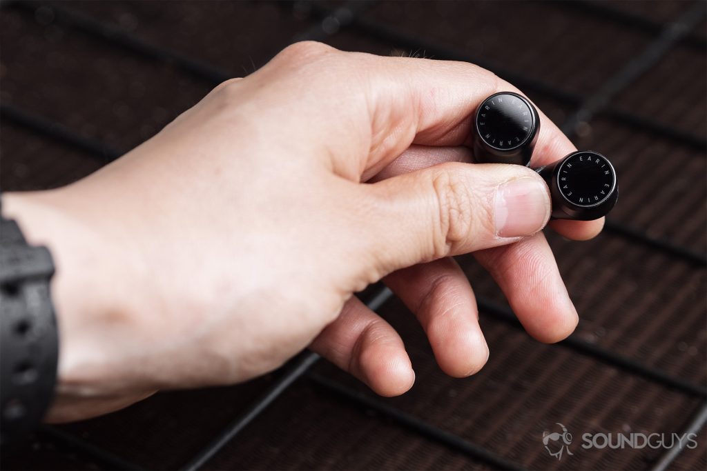 Earin M-2 review: The earbuds are in the hand, showing off the touch control panels.