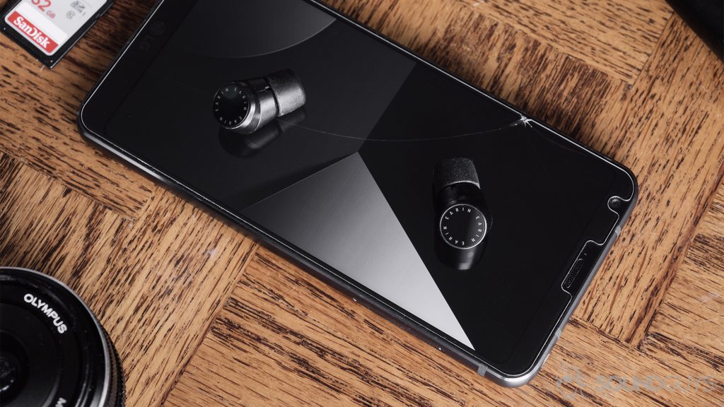 AirPods alternatives - Earin M-2 review: The earbuds resting on an LG G6 on a wood backgorund.
